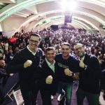 O senador Sergio Moro fala ao microfone em um púlpito durante evento político em Curitiba, cercado por apoiadores e bandeiras do Brasil e do Paraná ao fundo, ilustrando o lançamento de sua pré-candidatura.