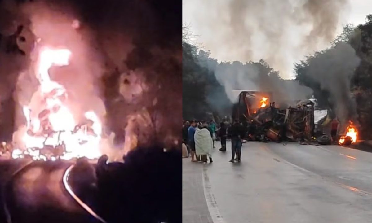 Imagem mostra o ônibus e a carreta em chamas após colisão frontal na BR-251, em Minas Gerais. A fumaça toma conta da rodovia enquanto pessoas acompanham o trabalho de resgate.