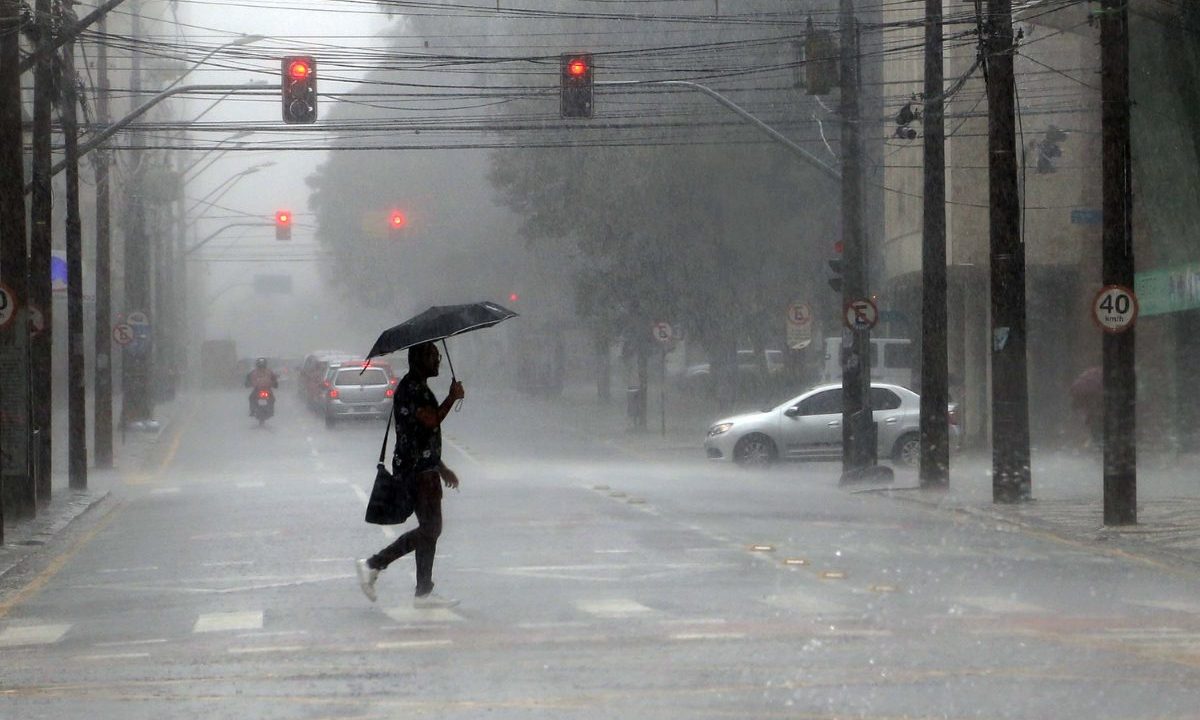 foto de uma pessoa andando na chuva para ilustrar o alerta amarelo de tempestades no paraná