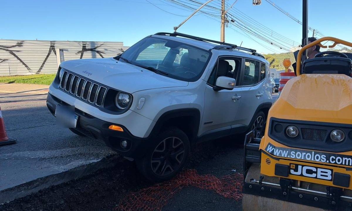 Foto mostra carro preso em canteiro de obras
