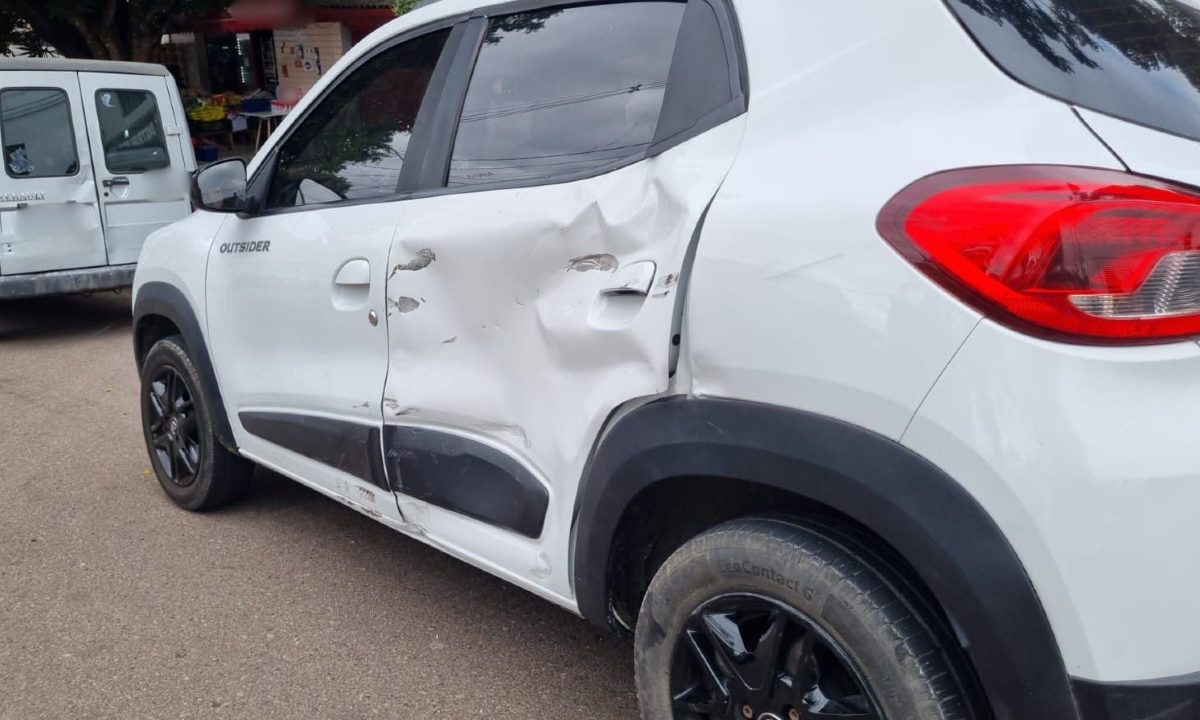 Lateral de carro branco danificada após colisão envolvendo uma moto no Bairro Alto, em Curitiba.