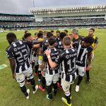 Jogadores do Operário reunidos no gramado do Couto Pereira antes da semifinal contra o Coritiba durante o Campeonato Paranaense de 2026, com as arquibancadas do estádio ao fundo.