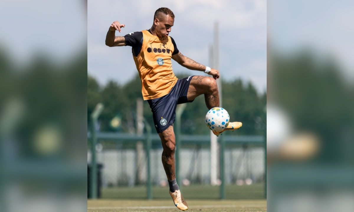 O atacante Breno Lopes aparece durante treinamento do Coritiba no CT da Graciosa. O jogador domina a bola no ar com a perna direita enquanto realiza atividade técnica em campo aberto. O atleta veste uniforme de treino do Coxa, com colete amarelo sobre a camisa verde.