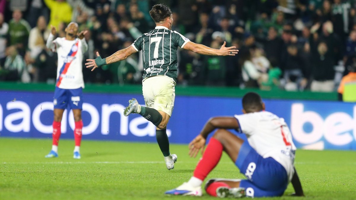 Lavega corre para comemorar o gol e é observado por dois jogadores do Bahia