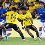 Jogador do Cruzeiro carrega a bola e é marcado por dois atletas do Barcelona do Equador