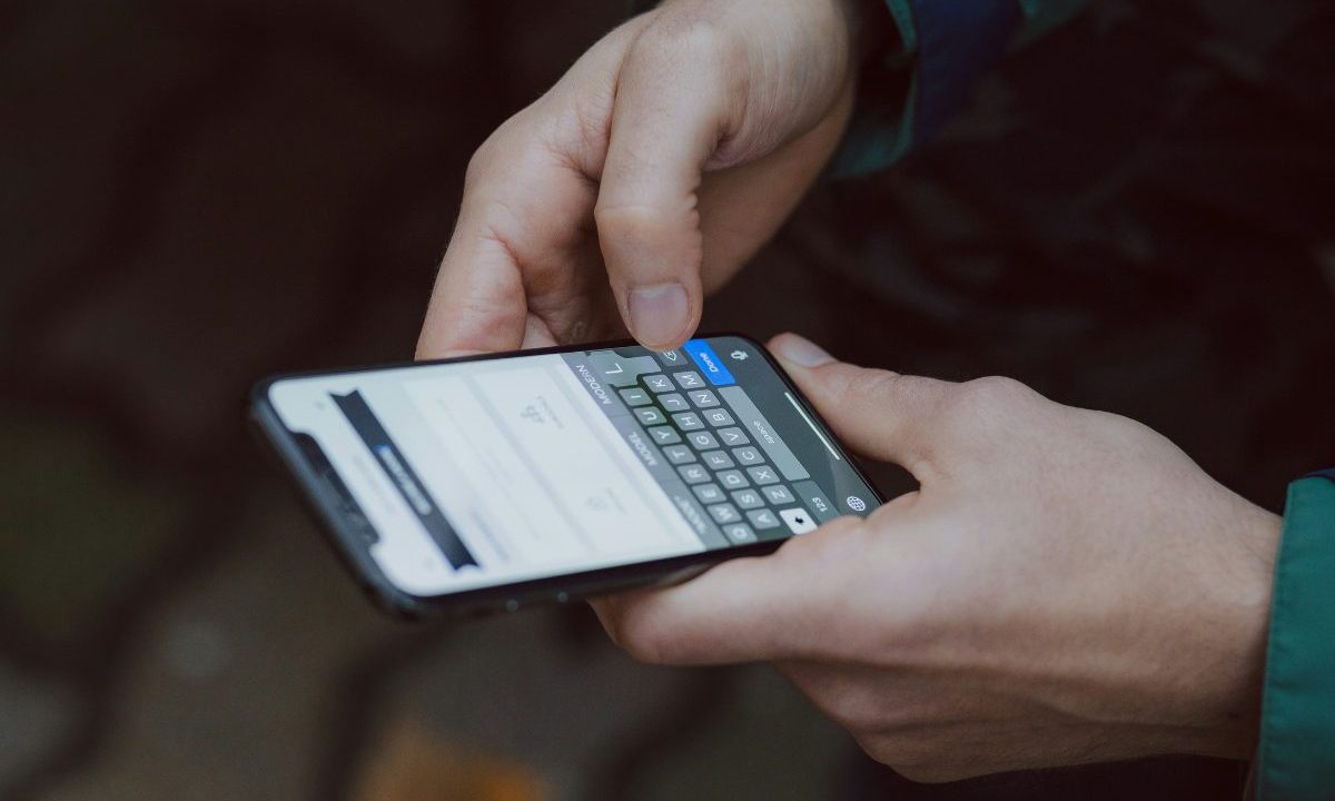 Homem digitando em celular; réu foi condenado por desejar feliz aniversário para Hitler