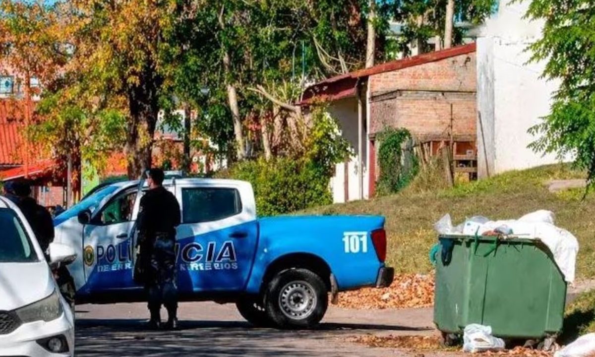 Policial e viatura da polícia da Argentina em local onde feto foi encontrado dentro de lixeira no meio da rua.