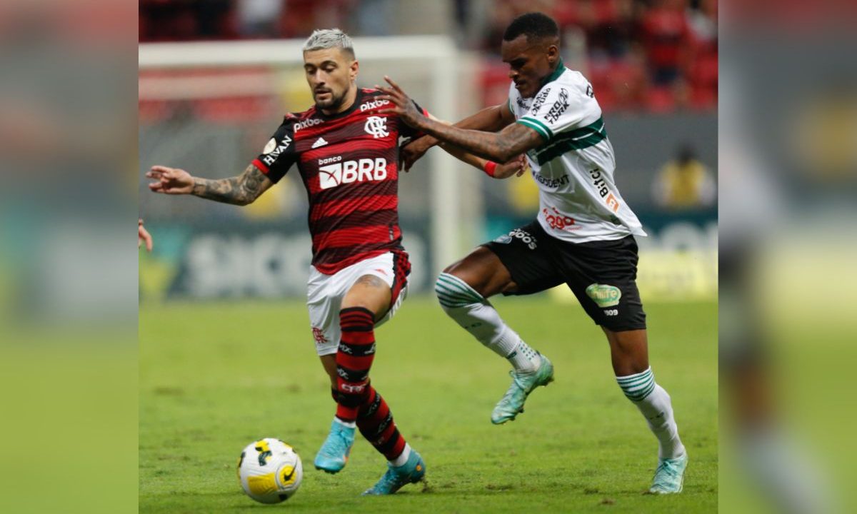 Na imagem, Arrascaeta, do Flamengo, disputa jogada com um jogador do Coritiba durante partida no estádio Mané Garrincha, em Brasília, pelo Campeonato Brasileiro de 2022.