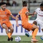 Jogador do Fluminense disputa a bola com dois atletad o La Guaira