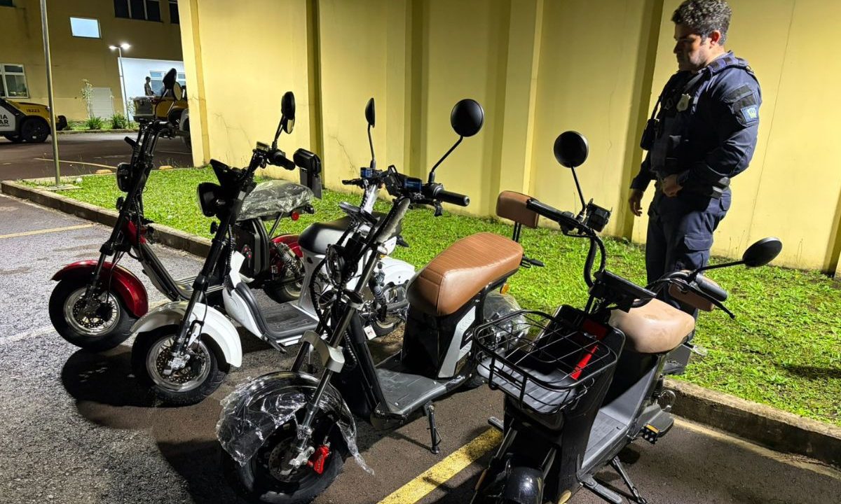 Guarda municipal ao lado de motos elétricas recuperadas em São José dos Pinhais. Golpe do falso Pix acaba em prisão.