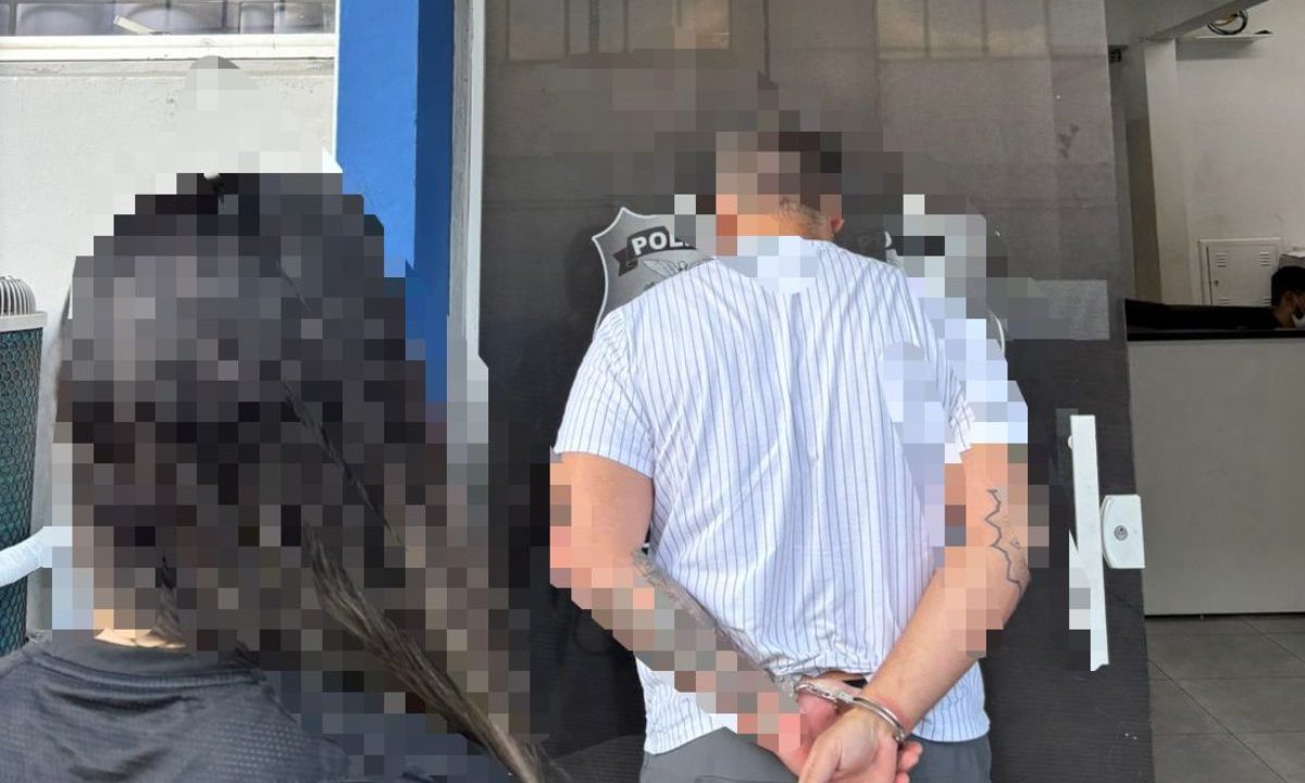 Homem condenado por estupro de vulnerável é levado algemado por policiais após prisão em São José dos Pinhais.