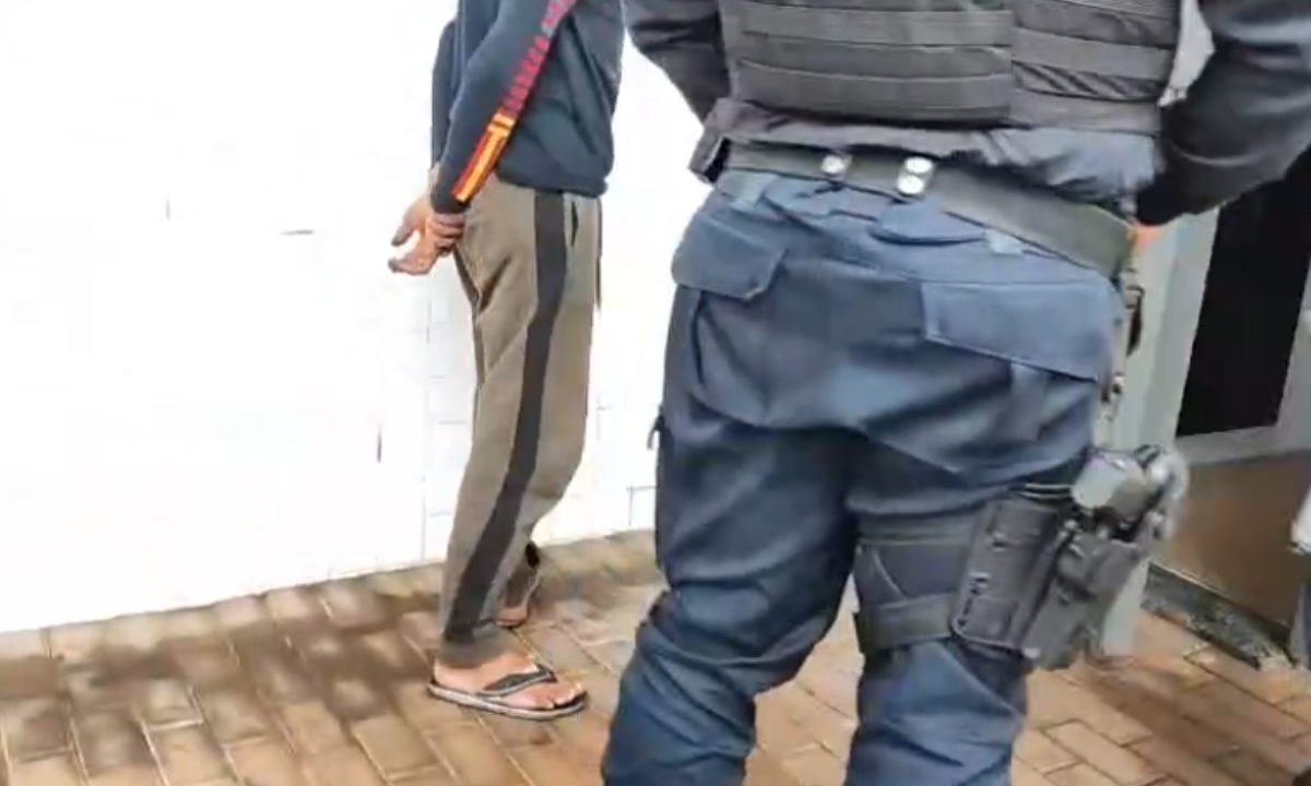 Imagem mostra homem sendo preso, suspeito de agrerdir a mãe idosa.