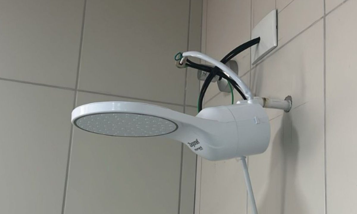 Chuveiro elétrico instalado em um banheiro, ilustrando o alerta do Corpo de Bombeiros sobre o uso correto de aparelhos elétricos durante o inverno.