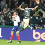 Joaquín Lavega salta e comemora pelo Coritiba no Couto Pereira, enquanto um jogador do Bahia aparece ao fundo durante partida do Campeonato Brasileiro.