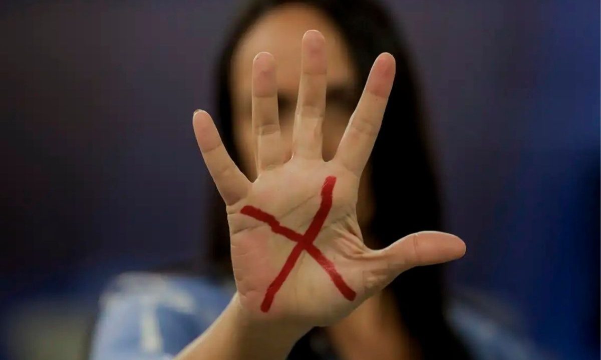 Nova Lei Bárbara Penna aumenta punições para condenados por violência doméstica que ameaçarem vítimas. A imagem mostra uma mulher com a mão aberta, na qual tem um X, representando um peddo de não violência.