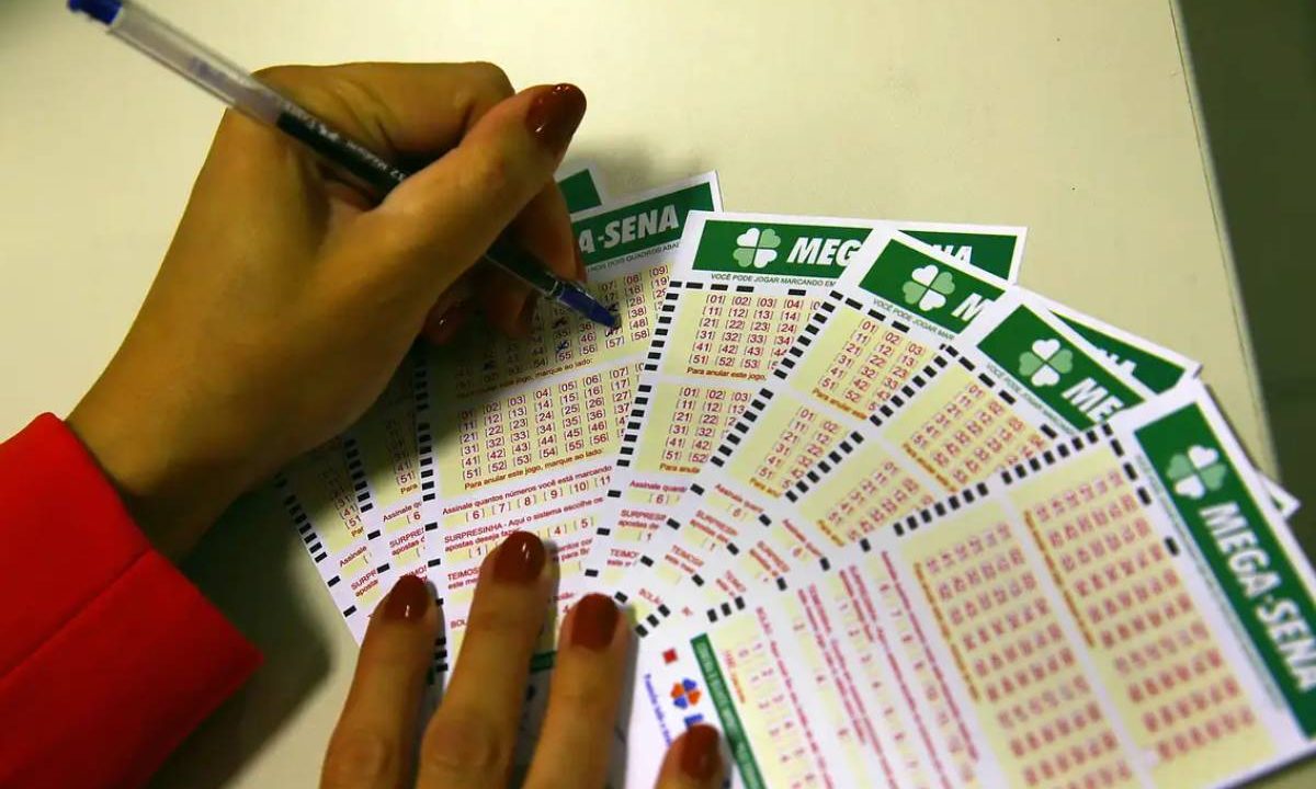 Pessoa marcando os números a caneta do volante da Mega-Sena. Imagem ilustrativa para matéria sobre sorteio de R$ 52 milhões da Mega-Sena que acontece hoje.