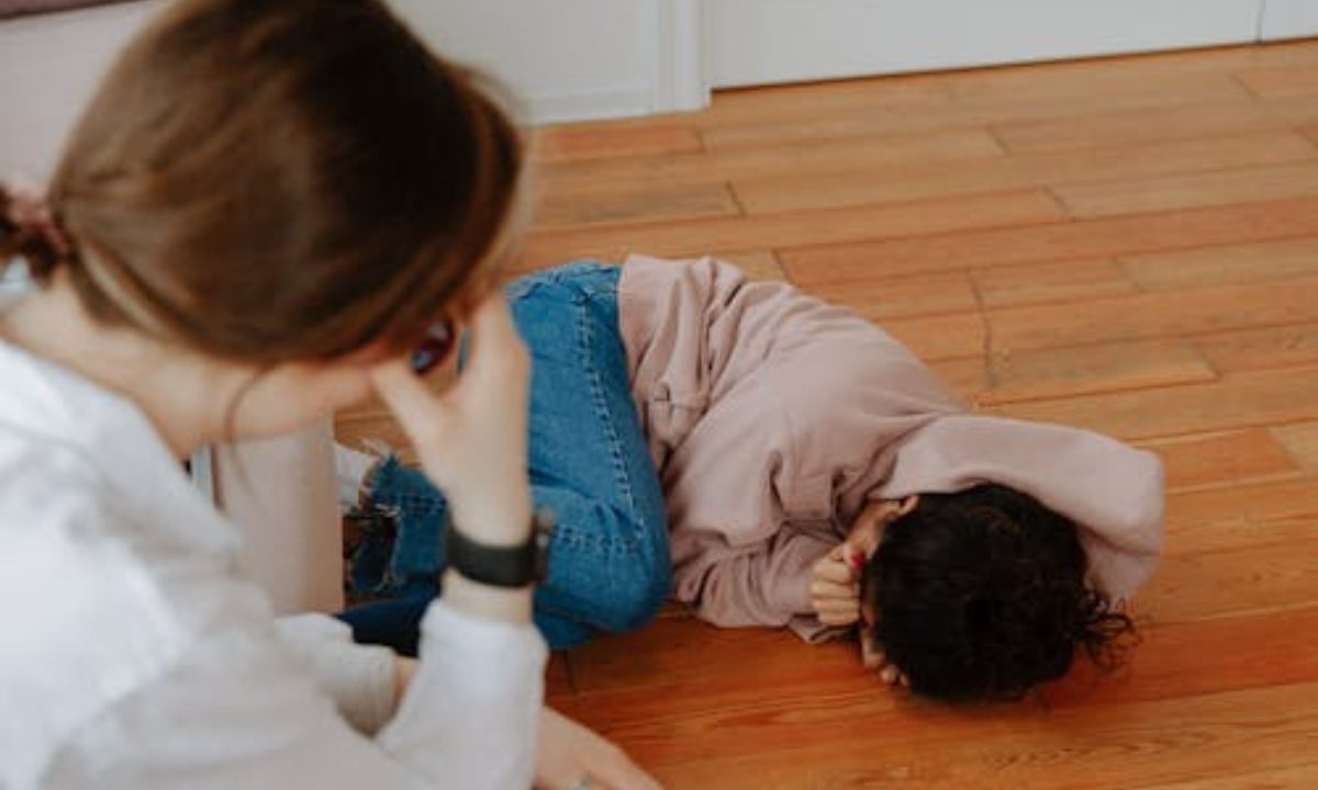 Menina chorando na frente da mãe para representar menina abusada por conhecido da família