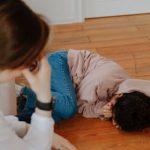 Menina chorando na frente da mãe para representar menina abusada por conhecido da família