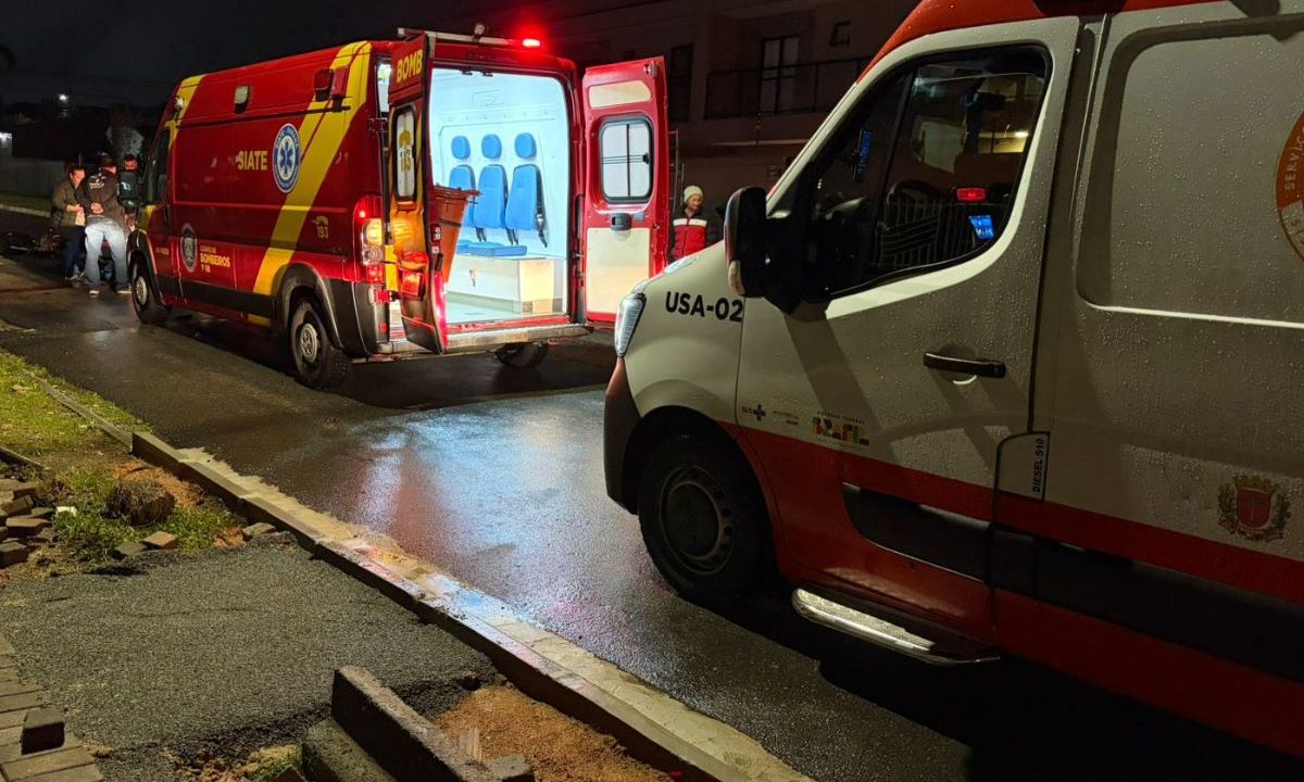 Socorristas atendem motociclista ferido em acidente no bairro Santa Felicidade, em Curitiba. Vítima bateu em caminhão parado.