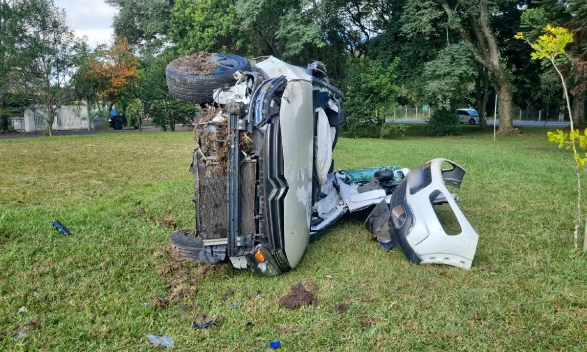 Carro completamente destruído depois de capotar no bairro Bacacheri, em Curitiba. Bombeiros cortaram a carroceria para retirar o motorista preso às ferragens.