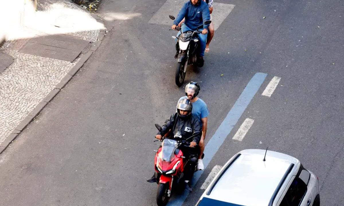 Dois motociclistas carregando passageiros na garupa de suas motos.. Imagem ilustrativa para matéria: Nova lei proíbe motos com duas pessoas; multa para quem descumprir regra pode chegar a R$ 2,1 mil