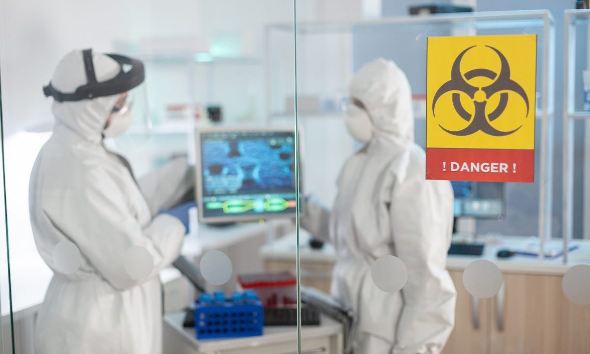 Profissionais de saúde usando equipamentos de proteção durante atendimento em área afetada por surto de ebola na África.