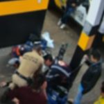 Imagem mostra um policial e um socorrista do Samu reanimando uma passageira em um posto da Polícia Rodoviária Estadual. A mulher foi reanimada após 40 minutos de massagem cardíaca. O policial e o socorrista estão agachados em torno da mulher. Outras pessoas estão ao redor olhando a situação.