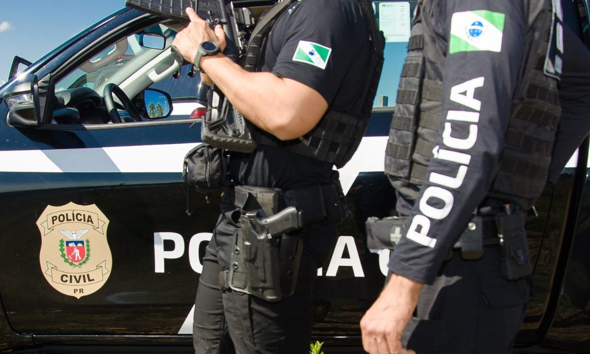 Policiais civis armados ao lado de viatura da PCPR durante operação policial no Paraná.