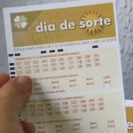 Mão segurando volante do Dia de Sorte 1219.