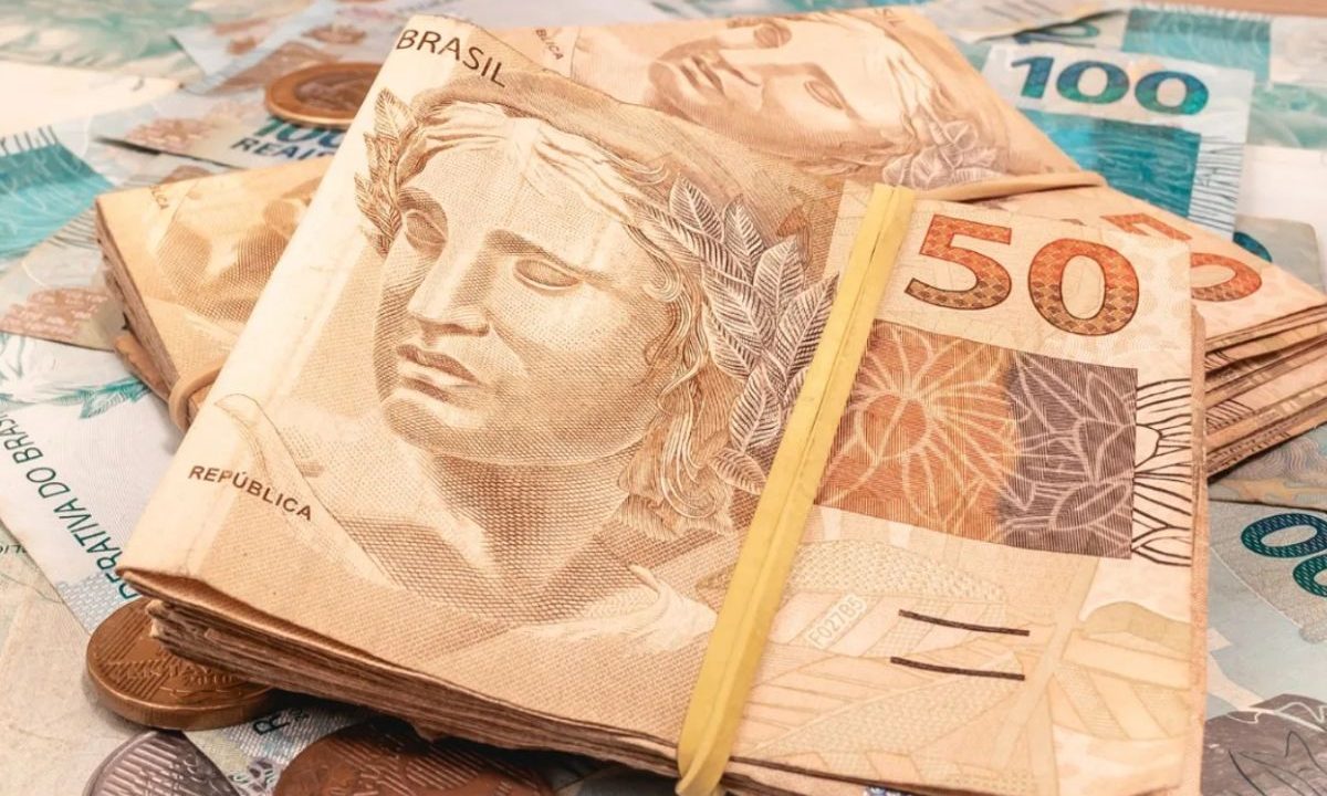 Notas de R$ 50 e R$ 100, presas por elástico, representando o quinto prêmio da Loteria Federal.