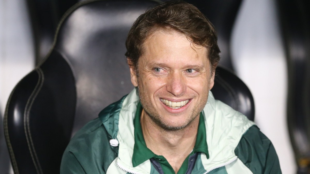 Técnico Fernando Seabra, do Coritiba, sorri e olha para o lado sentado no banco de reservas antes do jogo com o Bahia