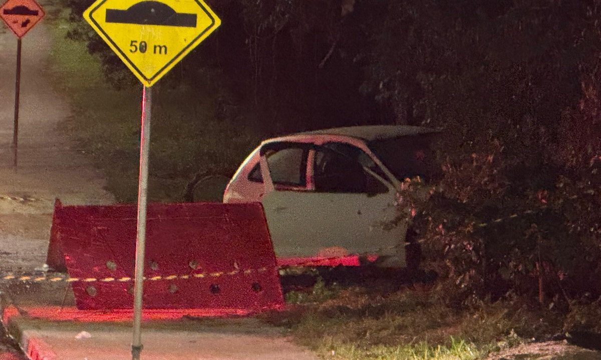 Foto tirada durante a madrugada mostra veículo branco com as portas abertas e parado parcialmente dentro do matagal. Carro era dirigido pelo suspeito que morreu em confronto depois de atirar contra policiais