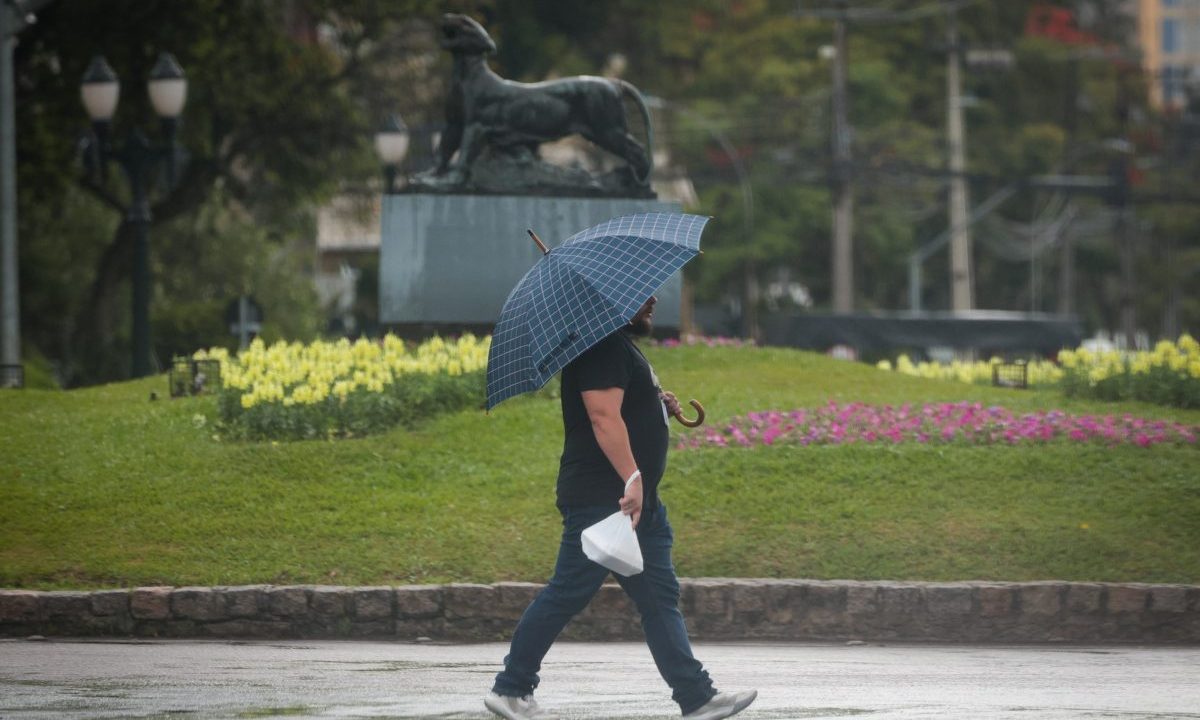 foto de um homem andando com sombrinha para ilustrar retorno da chuva em curitiba, conforme a previsão do tempo