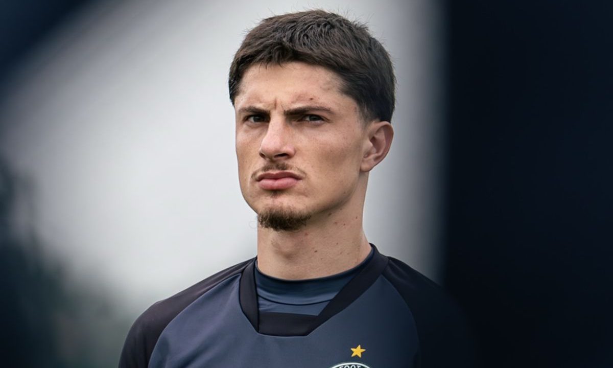 O zagueiro Tiago Cóser aparece em destaque durante treinamento do Coritiba. O jogador veste uniforme escuro do clube e olha para frente em campo aberto. O defensor será julgado pelo STJD após expulsão contra o Vitória no Brasileirão.