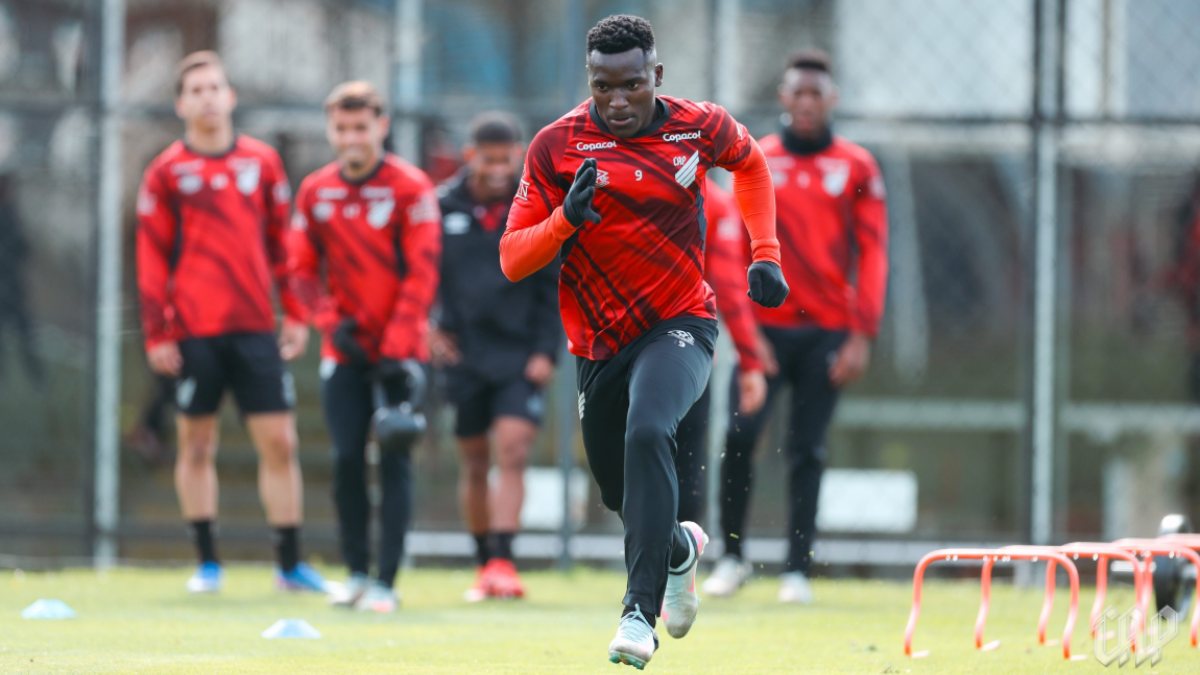 Treino do Athletico, com o atacante Viveros correndo e sendo observado por outros jogadores