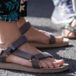 Foto de pés de turista calçados com chinelo e sandálias após tomar multa