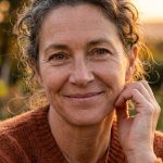 mulher de meia-idade sorrindo expressando resiliência e vantagem psicológica