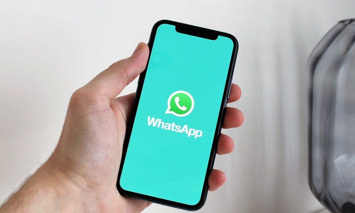 Celular com aplicativo WhatsApp aberto em imagem ilustrativa sobre figurinhas ofensivas.