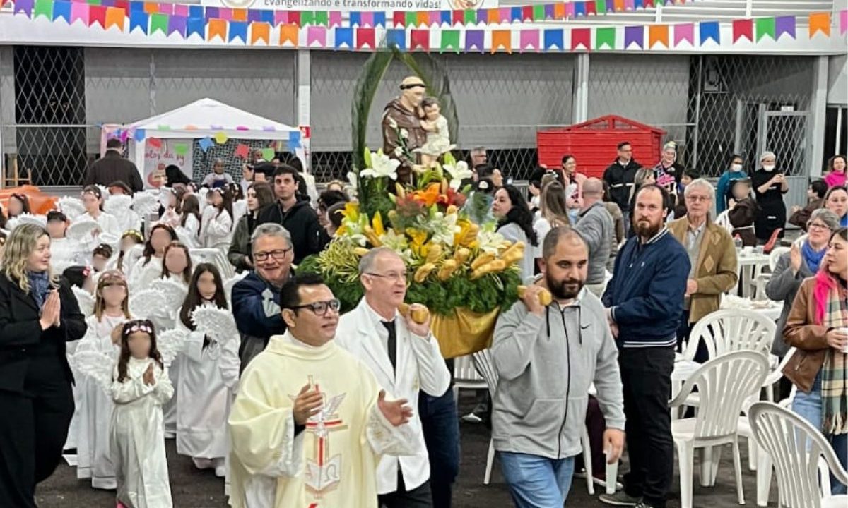 Procissão com altar de flores e fiéis reunidos no pavilhão da festa de Santo Antônio em Cascavel.