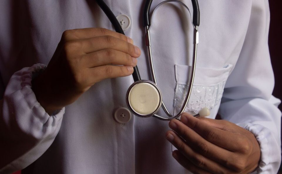 Mãos segurando um estetoscópio, representando um médico médico, que terá aumento no piso salarial, projeto criticado por ministro