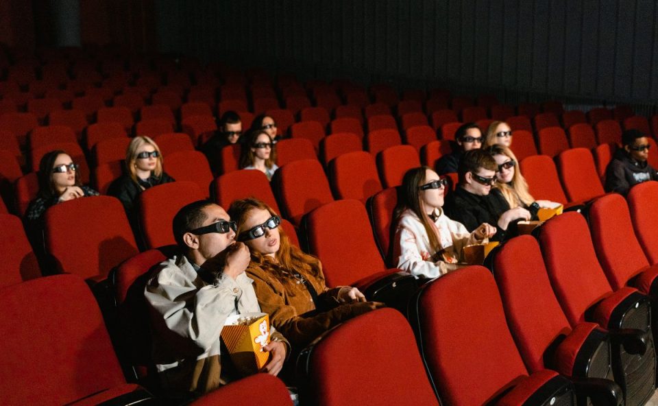 A imagem mostra alguns casais no cinema, no Dia dos Namorados o Shopping Curitiba fará uma promoção para os casais que se beijarem 