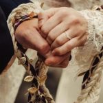 A imagem mostra um casal de mãos dados no Festival de Druidas