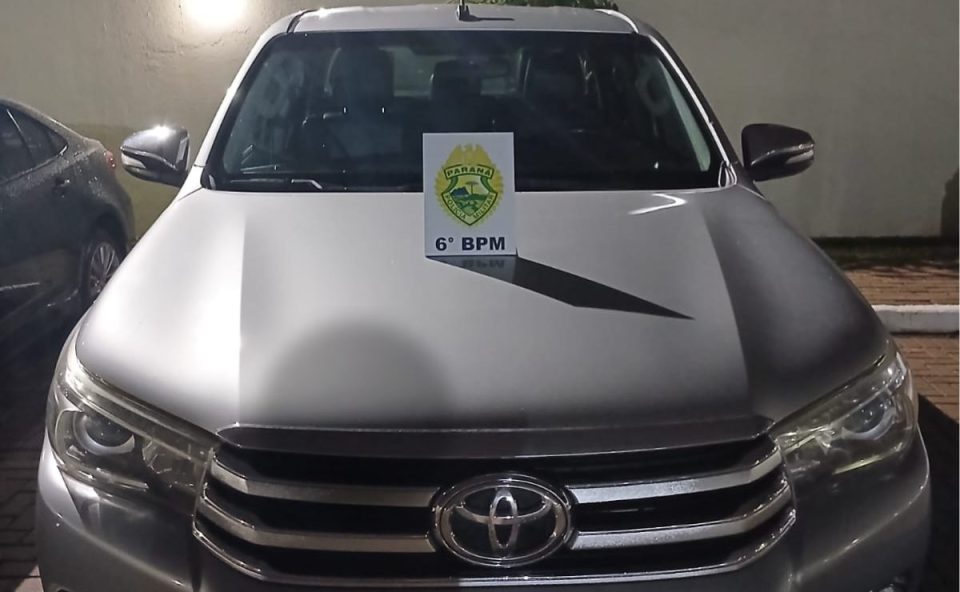 Visão frontal da caminhonete Hilux prata recuperada pela Polícia Militar em Cascavel após furto.