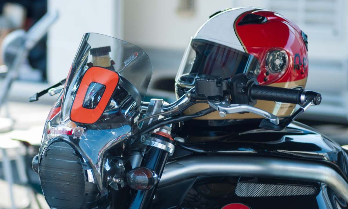 Capacete em cima de moto. Imagem ilustrativa para matéria: Novo selo com QR Code em capacetes pode mudar a vida do consumidor? Entenda o impacto da medida