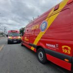 Duas ambulâncias vermelhas e amarelas do Siate do Corpo de Bombeiros estacionadas em uma rua residencial de Curitiba durante atendimento a vítimas da batida Uberaba.