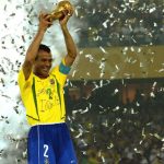 Cafú levanta a taça da Copa do Mundo em 2002 com a camisa da seleção brasileira. Em volta dele, papel picado