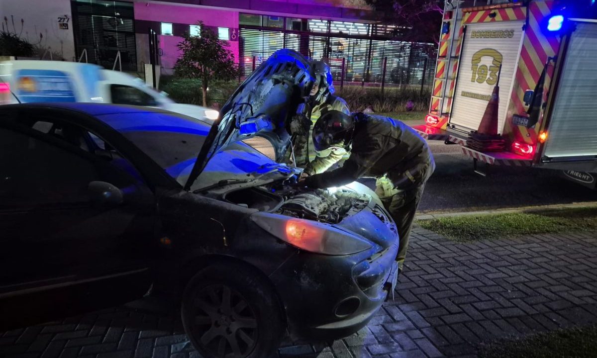 Corpo de bombeiros mexendo no carro após pegar fogo no Seminário