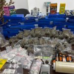 Foto mostra várias embalagens e porções de diferentes tipos de drogas sobre uma mesa em uma delegacia. Homem foi preso após ser abordado e PMs sentirem cheiro de maconha no carro dele