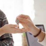 Mãos entregam a chave de um imóvel durante negociação de compra e venda, simbolizando a conclusão de um negócio imobiliário.