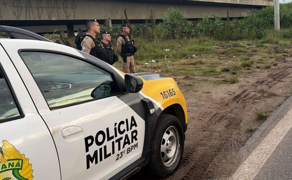 Viatura da Polícia Militar e policiais acompanham os trabalhos no local onde um corpo foi encontrado às margens do Rio Barigui, na Cidade Industrial de Curitiba.